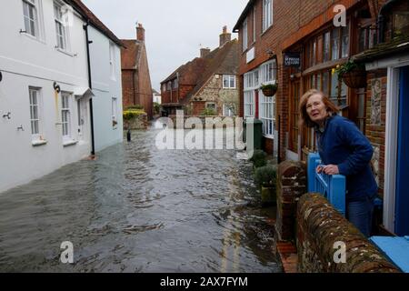 Bosham, West Sussex. 10th Feb 2020. UK Weather: A resident looks out from her home as tides rise in the wake of Storm Ciara and flood the village of Bosham, West Sussex, Uk Monday February 10, 2020.  Many places in the UK remain with yellow weather warnings as the Storm Ciara weather front continues.  Photograph : Luke MacGregor Credit: Luke MacGregor/Alamy Live News
