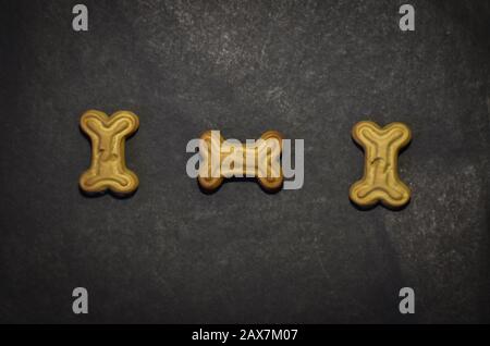 bone shape dog biscuit on the black background Stock Photo