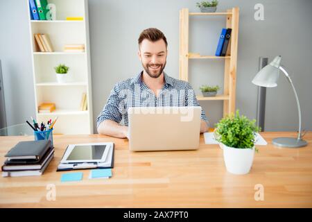 Portrait of cheerful successful businessman working in office on laptop Stock Photo
