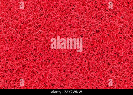 Close-up detail bright red plastic doormat seamless texture. Neutral abstract backdrop surface Stock Photo