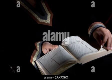 An arab woman reading the Holy Quran. Stock Photo