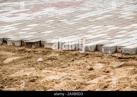 Laying of paving slabs on sand, repair and construction on the street Stock Photo