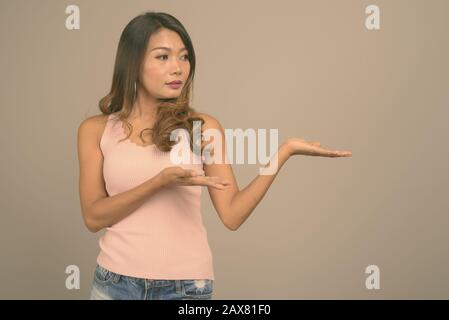 Portrait of Asian woman against gray background Stock Photo