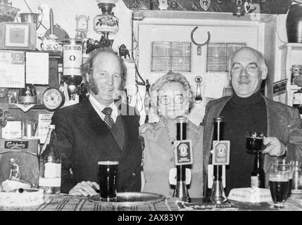 Emmerdale actors Ronald Magill (left) and Arthur Pentelow (right) behind the bar in The White Bear pub in Masham, Yorkshire, with landlady, Mary Gray. Stock Photo