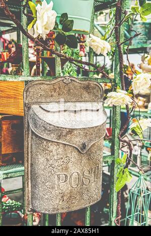 Post box. an old mailbox adapted for the work of florists hangs on the wall among the flowers. Close up. Stock Photo