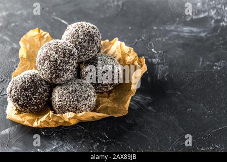 Homemade healthy protein energy balls in a coconut bowl with dried apricots, raisins, walnuts, almonds and coconut. Healthy sweet food Stock Photo