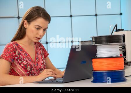 Young female designer works with a home 3D printer Stock Photo