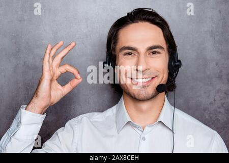 handsome young operator in call-center with headphones showing ok Stock Photo