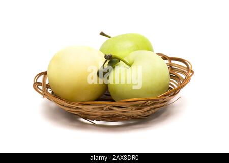 Three green apples in a basket on a white background Stock Photo