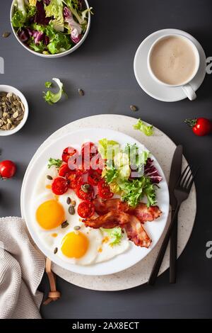 healthy keto diet breakfast: egg, tomatoes, salad leaves and bacon Stock Photo