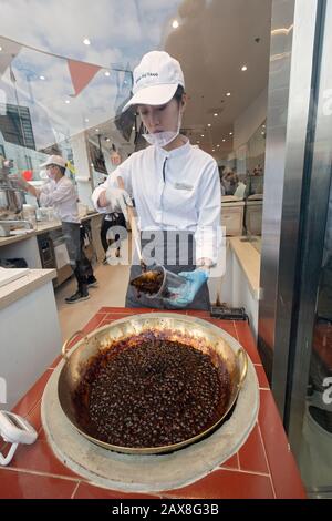 A young Asian American makes a boba milk drink in the window at Xing Fu Tang, a Taiwanese store on Main St. in Flushing, Queens, New York's Chinatown. Stock Photo