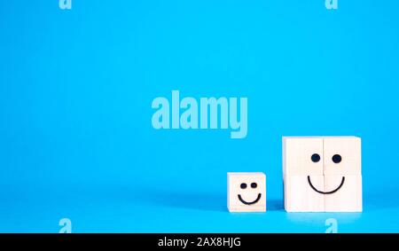 Two wooden blocks with happy faces, smile as they stand side by side. Stock Photo