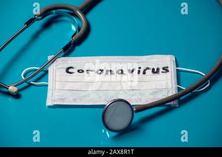 Mask with word-coronavirus and phonendoscope on blue background. Medine and healthcare concept Stock Photo