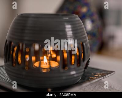 Aroma lamp with burning candle and essential oil on a plate. Spa room hotel. Stock Photo