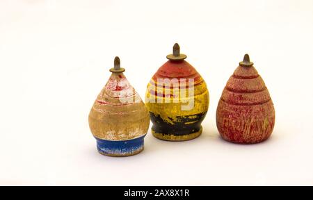 Used vintage wooden spinning top toys isolated on a white background image in horizontal format with copy space Stock Photo