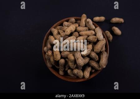 Peanuts in a bowl of mud Stock Photo