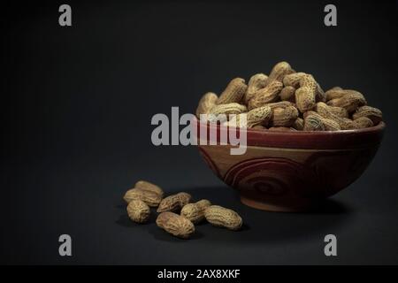 Peanuts in a bowl of mud Stock Photo