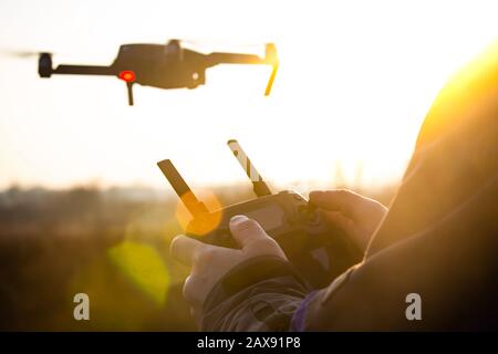 Man operating drone / man holding remote control drones / drone controller. Stock Photo