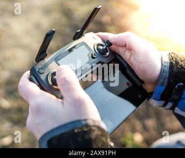 Man operating drone / man holding remote control drones / drone controller. Stock Photo