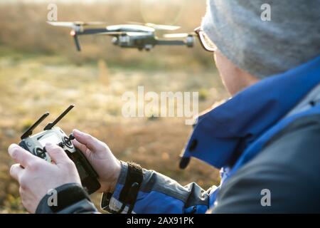 Man operating drone / man holding remote control drones / drone controller. Stock Photo