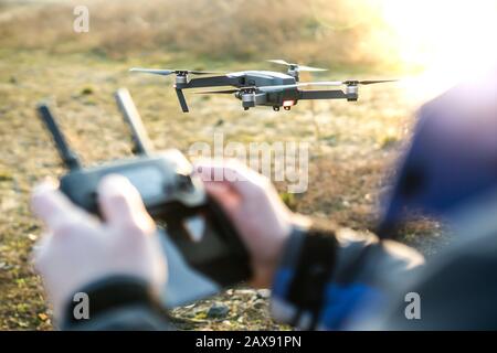 Man operating drone / man holding remote control drones / drone controller. Stock Photo