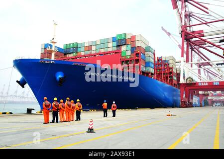 A container ship is docked on a quay at the Port of Qingdao in Qingdao City, east China's Shandong Province on February 11th, 2020. Stock Photo