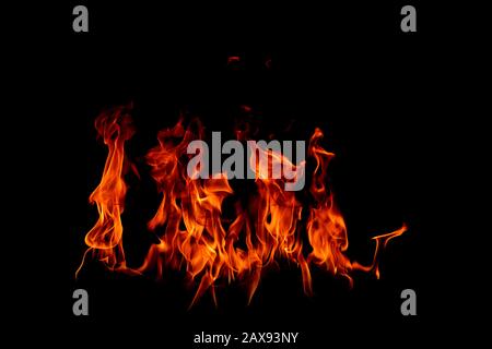 On fire flames at the black background, Burning red hot sparks rise, Fiery orange glowing flying particles Stock Photo