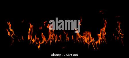 On fire flames at the black background, Burning red hot sparks rise, Fiery orange glowing flying particles Stock Photo