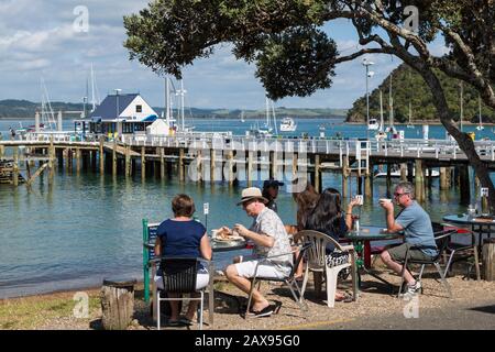 People eat at beach front cafe, Russell, Bay of Islands, New Zealand Stock Photo