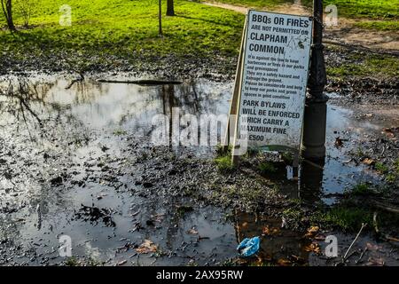 London, UK. 11th Feb, 2020. A pointless sign suggesting no fires or BBQ's stands in a puddle left by the recent storm. Credit: Guy Bell/Alamy Live News Stock Photo