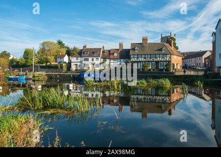 24th October 2018 - Tewkesbury, UK:Two people work on a small boat moored close by a picturesque group of cottages reflected in the tranquil River Avon near Abbey Mill in the town of Tewkesbury, Gloucestershire, Severn Vale, UK Stock Photo