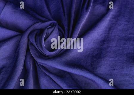 Texture, background, pattern. Fabric silk satin color cobalt, classic blue royal. Drape material in a flower shape. Stock Photo