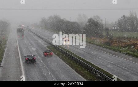 Moira, Northern, Ireland. 11th Feb, 2020. UK weather - widespread snow showers across Northern Ireland at all levels. Strong winds post Storm Ciara creating blizzard-like conditions. Motorway traffic on the M1 at Moira during another heavy snow shower. Credit: David Hunter/Alamy Live News Stock Photo