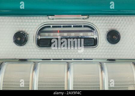 Retro styled image of an old car radio inside a green classic car Stock Photo