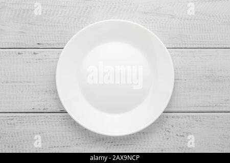 Empty white plate on gray wooden table. Top view. Wood board background Stock Photo