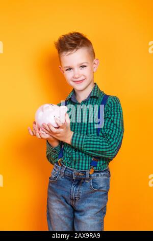 children's financial literacy. Happy kid with moneybox Stock Photo