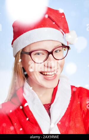 laughing young woman as Santa Claus with hat in the snow Stock Photo