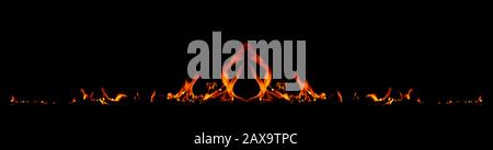 On fire flames at the black background, Burning red hot sparks rise, Fiery orange glowing flying particles Stock Photo