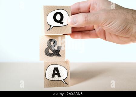 Q and A question and answers concept with speech bubbles on wooden blocks stacked on one another Stock Photo