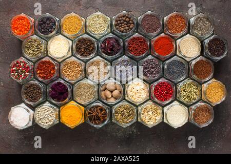 Different kinds of spices and herbs in glass on grey background Stock Photo