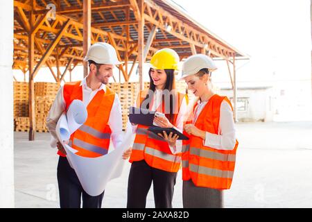 Team of young architects using tablet and blueprints Stock Photo