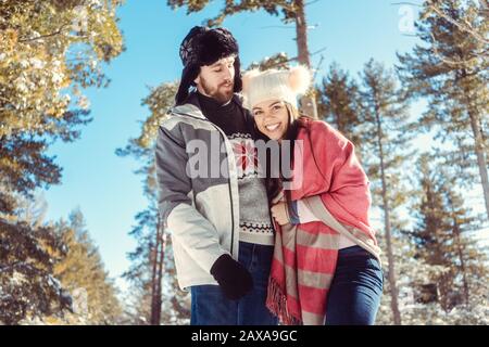 Winter couple in the forest enjoying the season Stock Photo
