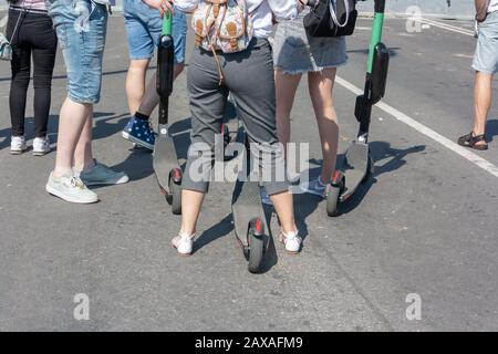 happy group of tourists with electric scooters talking Stock Photo