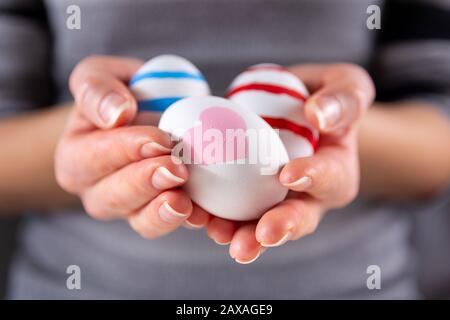 Girl hands with Easter colorful eggs. Girl holding group of painting eggs in hands indoor. Easter holiday concept. Close up, selective focus Stock Photo