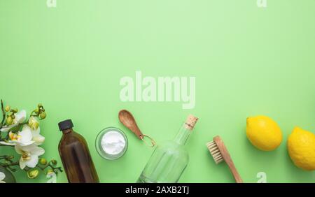 Eco cleaning household background. Cleaning products homemade safe non toxic flat lay, baking soda, lemon vinegar and fresh spring blossoms on green c Stock Photo