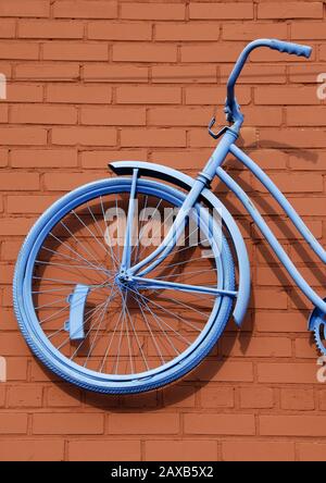 Antique Girls Bicycle Painted Blue against Rust Colored Brick Wall Stock Photo