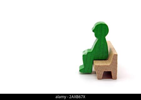 Male wooden figures sitting on a bench, concept, isolated on a white background Stock Photo