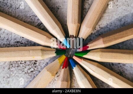 Many different colored pencils in a circle on gray background Stock Photo