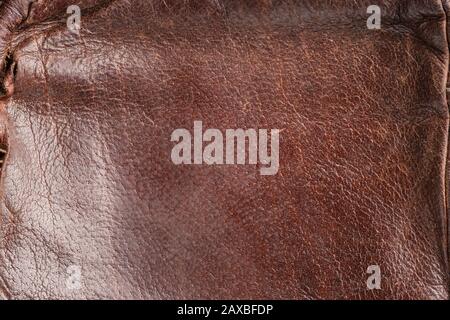 brown background-leather fabric, close-up leather with a reddish tint. Old, stylish, worn. Beautiful texture for designers, design and layouts, Seam, Stock Photo