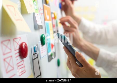 UI website designers are developing a mobile phone application interface. User experience Stock Photo